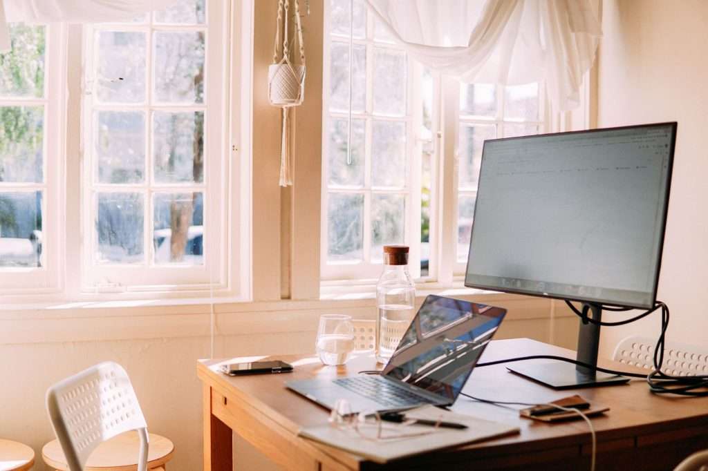 white laptop and monitor on table